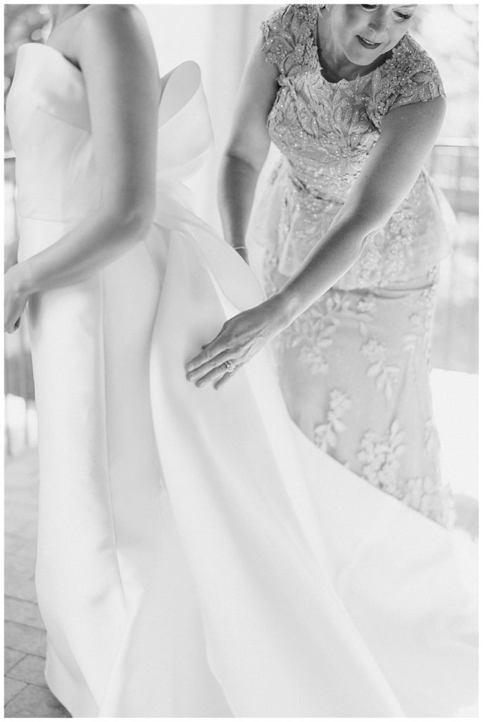 mother of bride fixes bride's dress